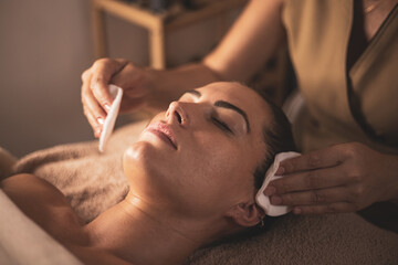 A young woman undergoes facial biotherapy in an aesthetic clinic.Concept of taking care of yourself.