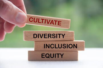 Hand holding wooden block with text - Cultivate diversity, inclusion and equity. Business culture concept
