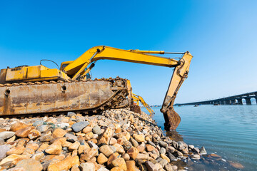 A row of excavators working on seaside