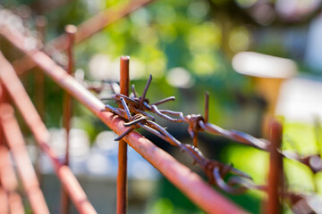 close-up of barbed wire fencing private territory from unauthorized persons painted red. Escape.