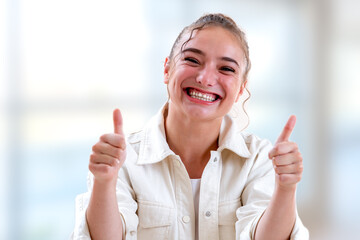 Young woman bursting out laughing on a light and blurry background
