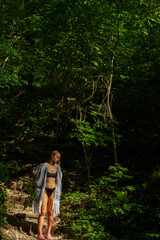 Fototapeta na wymiar beautiful blonde in a swimsuit walks in the mountains