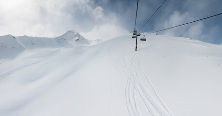 View from the outside of the aerial passenger line of a ski resort in winter in sunny weather...