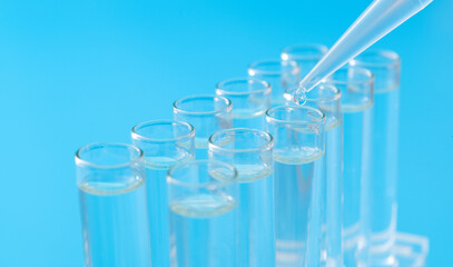 Liquid drop to test tube on blue background