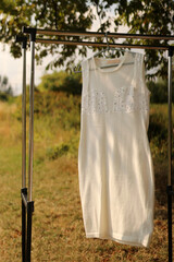 A white dress with overlays hangs on the hanger.