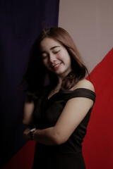 Naklejka premium Young Asian women wear dresses or dark clothes. Take pictures and express themselves inside the indoor studio.