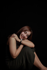 Fototapeta premium young Asian women wear dresses or dark clothes. Take pictures and express themselves inside the indoor studio. On a dark black background.