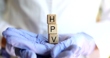 Doctor holds cubes with text HPV closeup