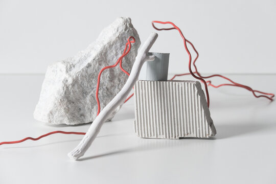 Horizontal studio shot of still life composition made of various white objects and red wire, white background