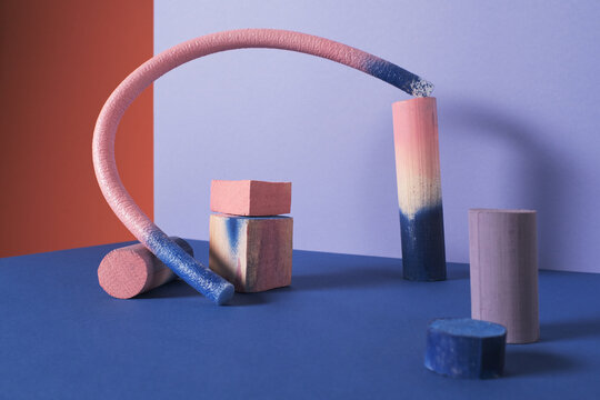 Horizontal studio shot of contemporary pink and blue still life installation of various gypsum, wooden and plastic objects
