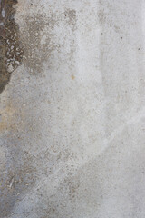 Abstract background from the surface of an old gray wall damaged by time.