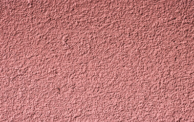 Abstract background of red rough plaster spoiled by time.