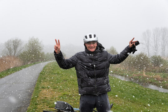 Forty Year Old Man With Bike And Helmet Standing In A Snow Storm In A Nature Reserve