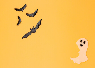 Halloween background with pumpkins, ghost, and bats, . Above view over an orange banner background with copy space.