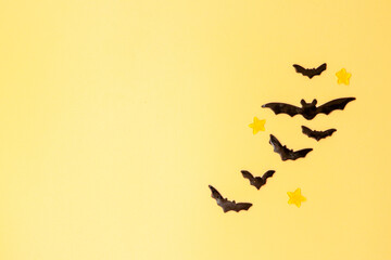 Halloween background with pumpkins, ghost, and bats, . Above view over an orange banner background with copy space.
