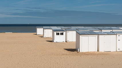 Knokke Heist, Flemish Region - Belgium - White beach cabins in a row at the sand beach during low season