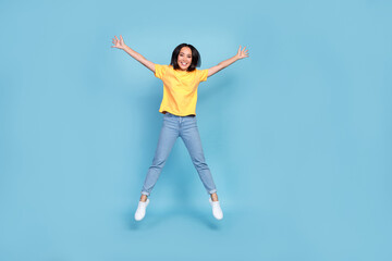 Fototapeta na wymiar Full size photo of charming cheerful girl jumping make star figure isolated on blue color background