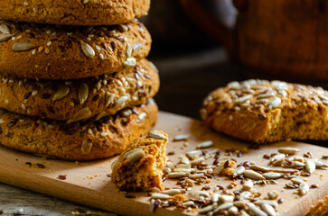 Oatmeal homemade cookies with grains on a wooden board, on the kitchen table and homemade coffee in a clay mug.
