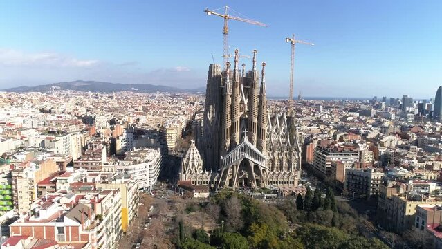 Aerial view of Barcelona city skyline and Sagrada Familia Cathedral at sunrise. Eixample residential famous urban grid. Cityscape with typical urban octagon blocks. Catalonia, Spain