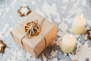 Christmas still life on the windowsill. Concrete background, gifts, candles and garlands