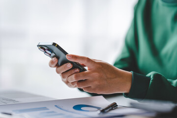 Close-up of a young woman holding a smartphone, typing messages, chatting with friends on social networks. Concept of using mobile applications Shopping online, browsing the web, ordering food