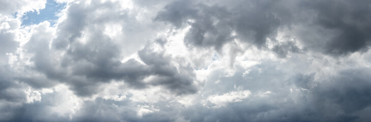 Gray storm clouds thickly covered the sky, sunlight penetrates through the clouds