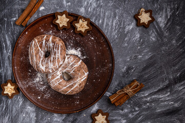 Homemade craft gingerbread cookies sprinkled with powdered sugar on a gray background