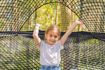 Child girl in nets playground.