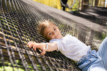 Child girl in nets playground.