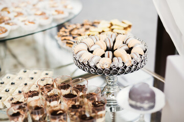 Delicious and tasty dessert table with cupcakes and shots at reception closeup