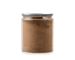 Transparent jar full of ground cinnamon on a white background.