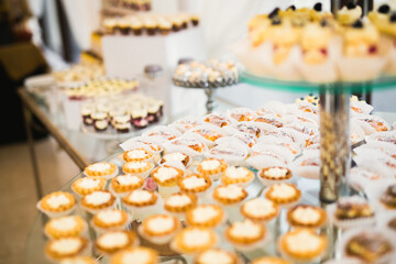 Delicious sweets on wedding candy buffet with desserts, cupcakes