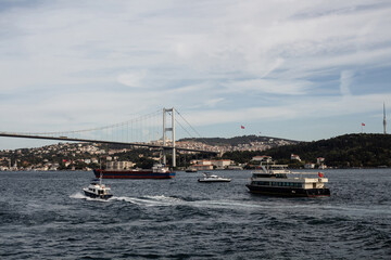 View of cruise tour boats and yachts, bridge and Asian side of Istanbul. It is a sunny summer day.