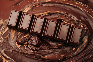 Chocolate bar lying on a solidified melted chocolate background