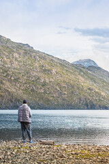 A man back side looking to lake and mountains