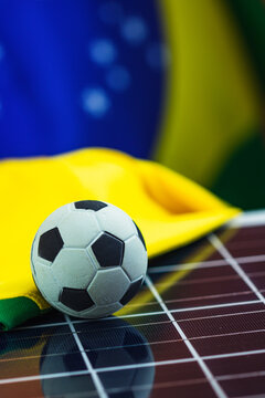 Soccer Ball and Brazil Flag over Photovoltaic Solar Panel. World Cup and Technology Concept Image for Design.