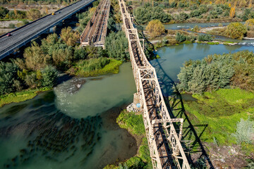 Aerial view of the railroad bridge above a river in Maule region, Chile. Top view of the railroad from drone.