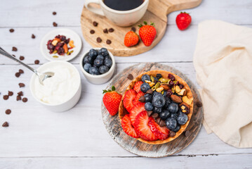Yogurt and fruit in a waffle bowl. Greek yogurt in ice cream waffle bowl with fruit and nuts, healthy diet friendly dessert. Fruity waffle bowl.