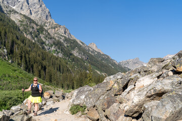 Woman hiker with a backpack on the Cascade Canyon trail in Grand Teton National Park. Left aligned,...
