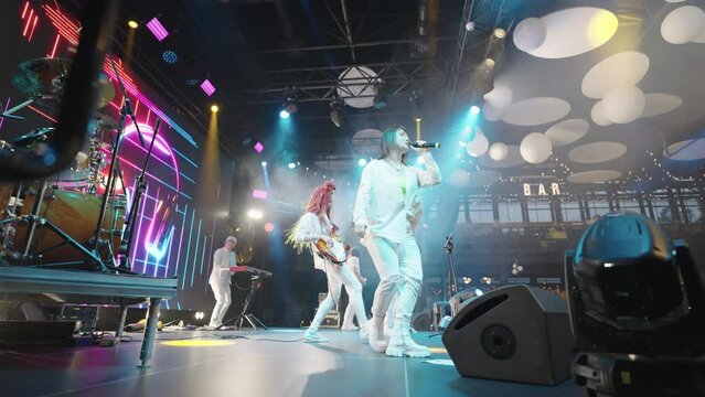 on stage during rock or pop music band concert, musicians and singers are performing, gig of hip-hop and funk