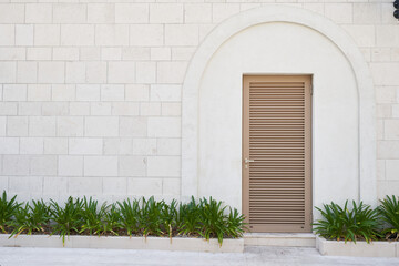 louvered plastic door on the stone wall