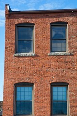 Exterior wall of brick mill building against bright sky in Haverhill