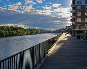 Wheelchair user on Wall street boardwalk at banks of Merrimack river in Haverhill
