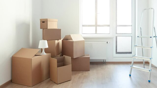 Different cardboard boxes for moving and ladder at room interior movement or delivery concept. Nobody