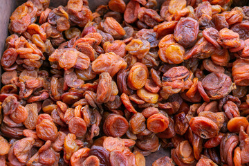 Dried apricot fruits forming a background. Dried apricots are dried pitted apricot halves.