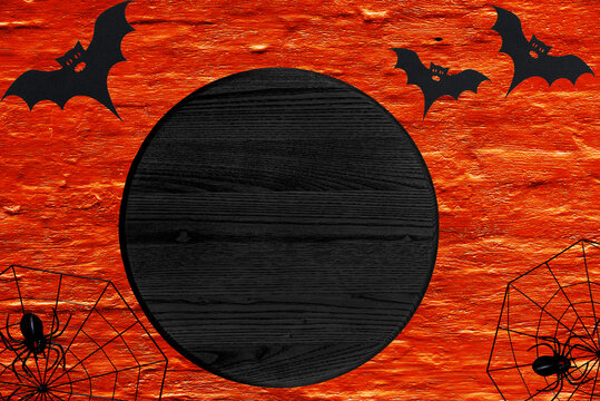 Black Blank Round Wood Sign With Copy Space Lies On Orange Background. Halloween Mockup Door Circle Sign.