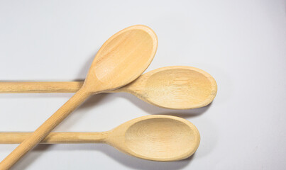 Closeup and top view of three wooden spoons isolated on white background.