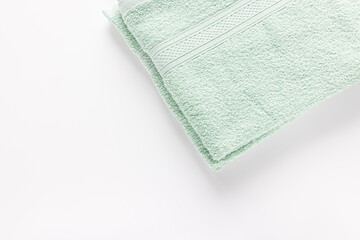 New folded mint green bath sheet or towels on white background, copy