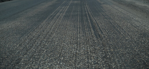 Naklejka premium Old asphalt. Budget repair of the road. Broken asphalt in the forest. banner