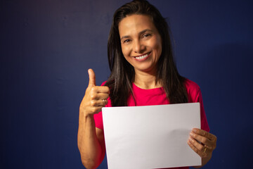 Mulher mulher morena indicando positivo com papel na mão